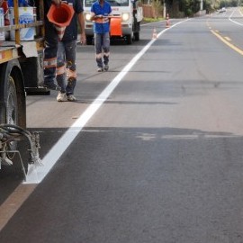 Na foto, destaque para  equipamento realizando sinalização de solo em rodovia.