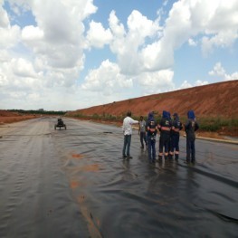 Na foto funcionários inspecionando a aplicação de mante de cobertura sobre o solo.